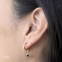 Load image into Gallery viewer, Close-up of an ear wearing a gold hoop earring with an eye design.