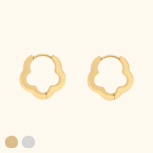 Load image into Gallery viewer, Gold-colored flower-shaped hoop earrings on a light yellow background