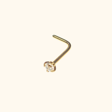 Load image into Gallery viewer, Gold nose ring with a small clear gemstone on a beige background