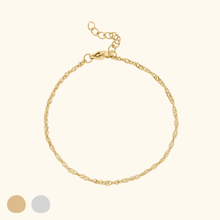 Load image into Gallery viewer, Gold bracelet on a light yellow background