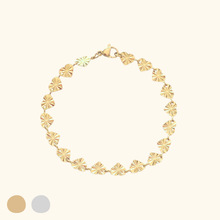 Load image into Gallery viewer, Gold bracelet with heart designs on a light yellow background.