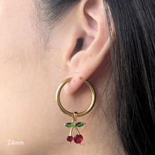 Load image into Gallery viewer, Gold hoop earring with cherry charm worn by a person

