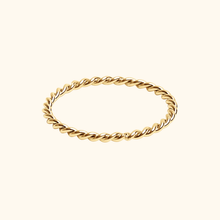 Load image into Gallery viewer, Gold-colored twisted ring on a light yellow background.
