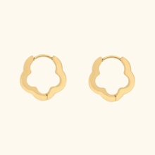 Load image into Gallery viewer, Gold-colored flower-shaped hoop earrings on a light yellow background
