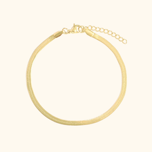 Load image into Gallery viewer, Gold bracelet on a light yellow background

