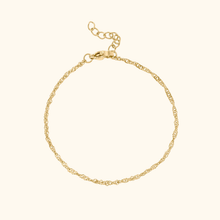 Load image into Gallery viewer, Gold bracelet on a light yellow background
