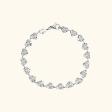 Load image into Gallery viewer, Stainless steel bracelet with heart designs on a light yellow background.
